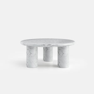 Table basse ronde Orbe sur trois pieds cylindriques, vue de face, configuration en marbre de Carrare.
